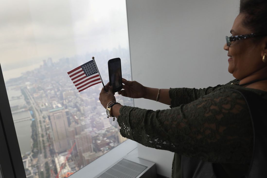 An immigrant takes a selfie after becoming a U.S. citizen at a naturalization ceremony held atop the One World Trade Center<br>